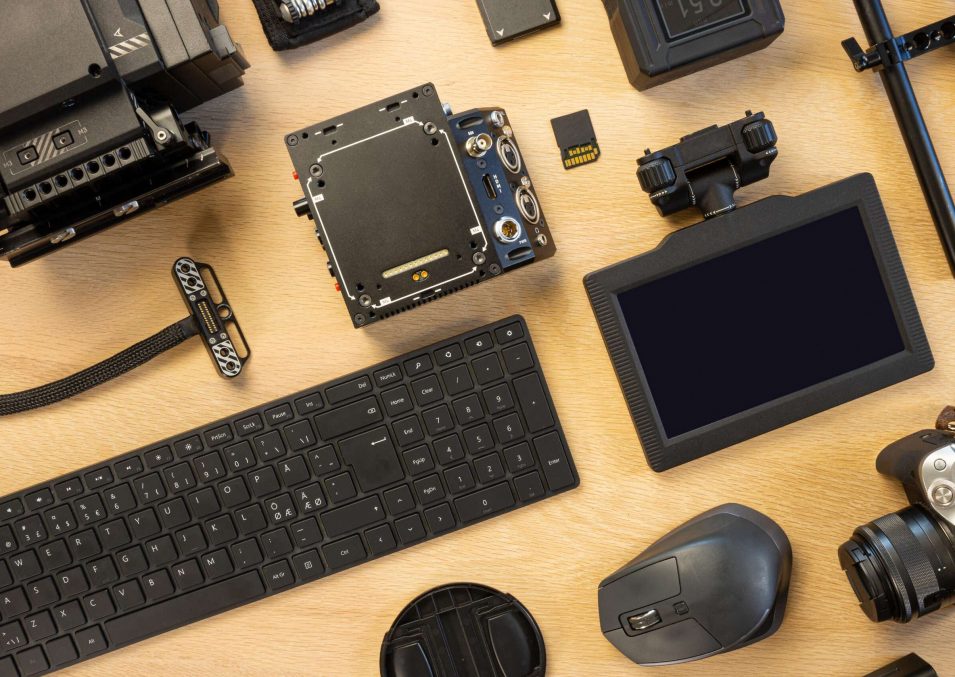 Overhead view of computer parts and filming accessories on table Flat lay of filming equipment with keyboard and mouse. Overhead view of video camera with computer parts on table. Directly above shot of various accessories arranged on surface.